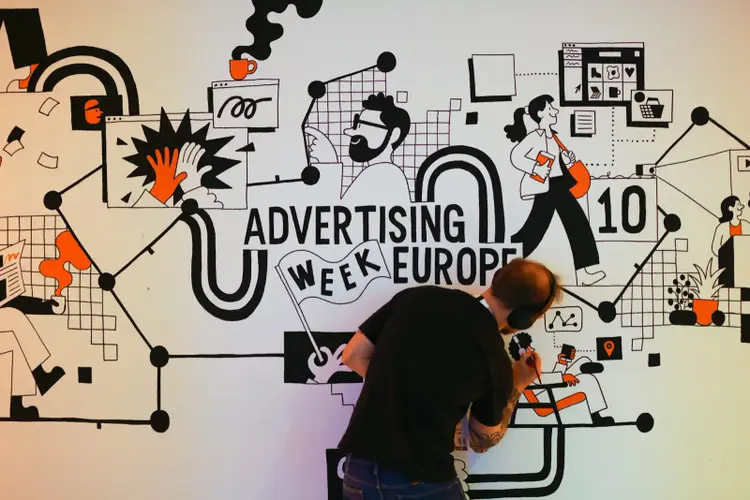 An artist illustrating an advertisement for Advertising Week Europe.