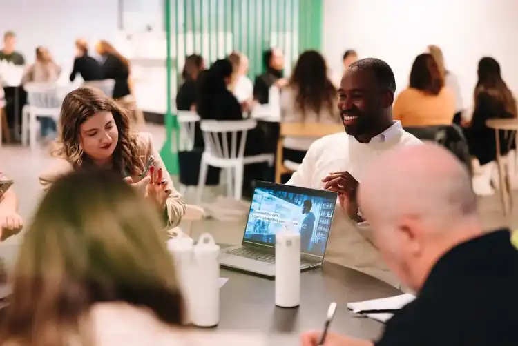 Professionals networking at indoor business event with laptops