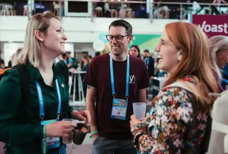 Conference attendees wearing badges networking at business event