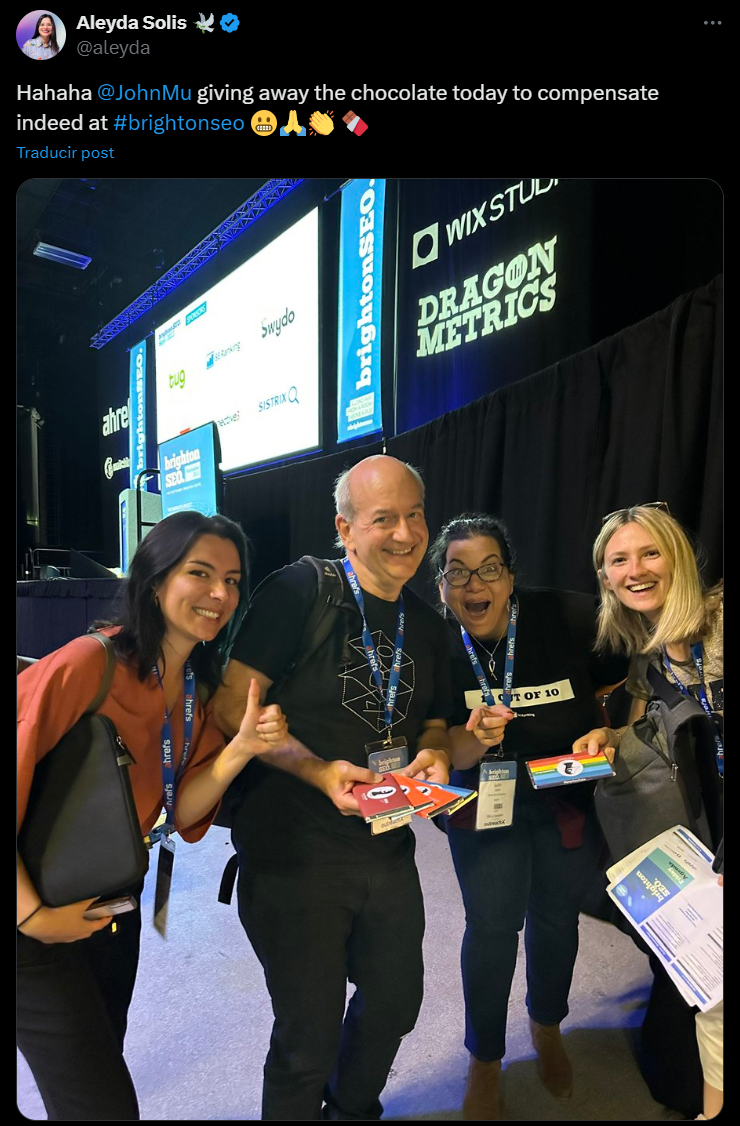 BrightonSEO San Diego attendees posing at booth with Dragon Metrics and Wix Studio signage