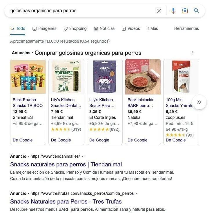 Google Shopping anuncios golosinas orgánicas perros con cinco productos, precios y valoraciones
