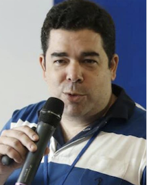 Palestrante no evento com microfone, camisa azul