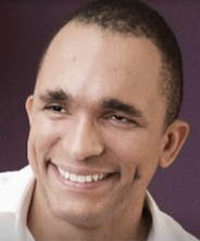 Homem barbudo sorrindo contra fundo roxo