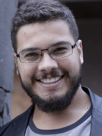 Barbudo com óculos sorrindo contra fundo blurred