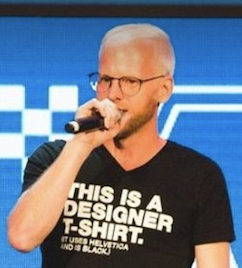 Palestrante no palco com microfone, camiseta designer